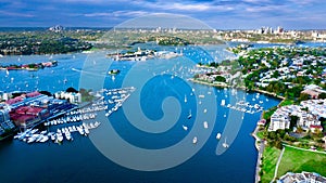 Drone Aerial view of Sydney Harbour Sydney CBD NSW Australia. cloudy dark skies, clear turquoise waters.