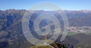 Drone aerial view to the Seriana valley and Orobie Alps in a clear and blue day. The cross at the top of the mountain