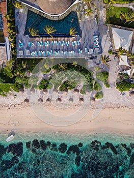 drone aerial view of tropical swimming pool by a blue ocean