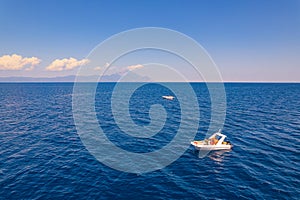 Drone aerial view of two white boats sailing through the sea in a beautiful sunny weather with Mt Athos in the