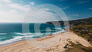Drone aerial view of unidentifiable kitesurfers at Guincho beach in Cascais, Portugal