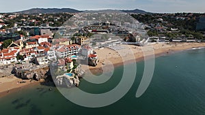 Drone aerial view of unidentifiable sunbathers at Praia da Rainha beach in Cascais, Portugal