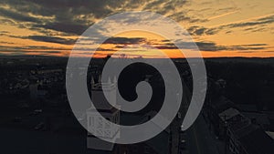 Drone Approaching a View of a Small Town and a Steeple at Sunrise as it gets Ready to Break