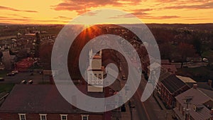 Drone Approaching a View of a Small Town and a Steeple at Sunrise as it gets Ready to Break