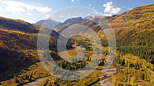 Drone Backwards Epic Autumn Landscape Aspen Trees McClure Pass Colorado Mountains. Winding rivers through mountain valley colorful