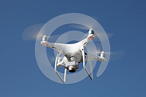 Drone on blue sky background. Remote control quadrocopter with camera for photography. Flying robot