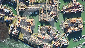 Drone, buildings and ocean with harbor in city for residential, infrastructure and property. Nature, environment and