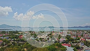 Drone camera flies above colourful asian city against blue sky