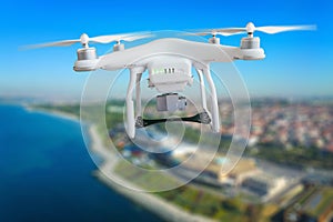 Drone with camera flying above city coasline photo