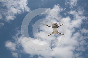 Drone with camera flying over the blue cloudy sky. Aerial landscape photography.