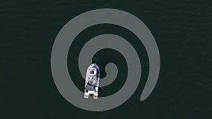Drone captures fisherman on boat in calm Baltic Sea waters off Kolobrzeg.
