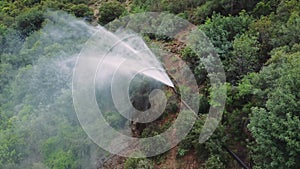 Drone captures fountain, pipeline burst in mountain canyon. Aerial view of fountain, pipeline releasing water. Visuals