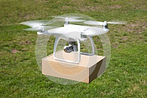 Drone carrying parcel over grassy field