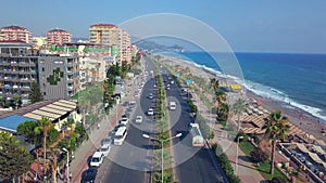 The drone. Clip. Flying over a beautiful ocean and a huge resort town with a beach, cars, traffic jams and big houses