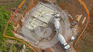 DRONE: Construction site crew pump cement onto the base for modern house.