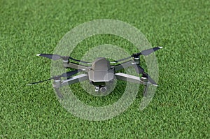 Drone copter with digital camera on grass floor .