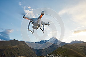 Drone copter flying with digital camera in mountains photo