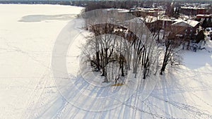 Drone crane view coming down near a small islands in the middle of the frozen river near St-Eustache