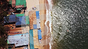 A drone descends from high ground to a beach restaurant