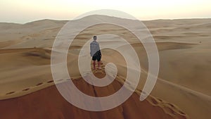 Drone, desert or travel man on sand landscape top view in Namibia sunset, nature beauty on dry land, horizon or Africa
