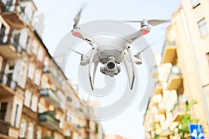 drone with digital camera flying at city street