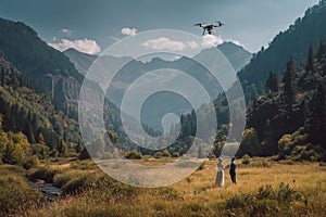 Drone filming bride and groom during wedding ceremony in a mountain valley with a river