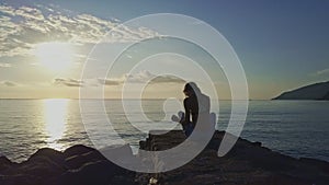 Drone Flies around Woman Doing Yoga against Sunrise Ocean Sky