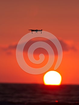 Drone flies over a colourful sunrise sky.