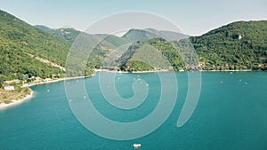 Drone flies over the lake in the mountains.