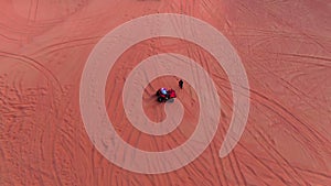 A drone flies over quad bikes driving through the sand dunes of the desert in the United Arab Emirates