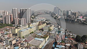 A drone flies over a residential area with small houses and multi-story buildings.