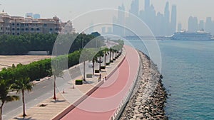 A drone flies over a road along the seashore near Dubai, United Arab Emirates