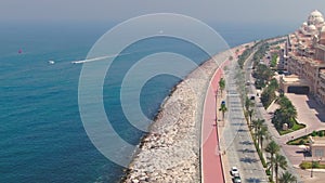 A drone flies over a road along the seashore near Dubai, United Arab Emirates