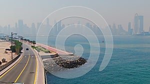 A drone flies over a road along the seashore near Dubai, United Arab Emirates