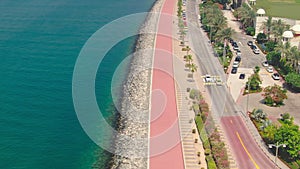 A drone flies over a road along the seashore near Dubai, United Arab Emirates