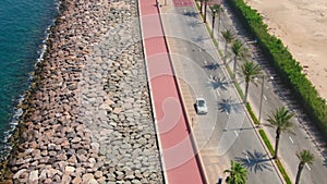 A drone flies over a road along the seashore near Dubai, United Arab Emirates