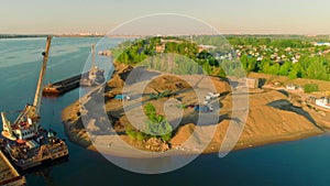 Drone flight over the sand and gravel mining on a sunny summer day near the river. Scene. Concept of heavy industry and