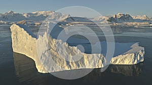 Drone flight over sunlit iceberg. Antarctica.