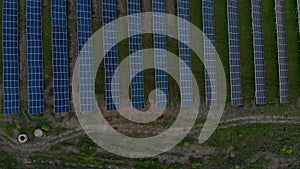 Drone fly over Solar Farm. Renewable green energy and electrical technology. Field of Solar Panels Stands in a Row in