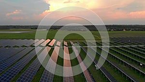 Drone fly over Solar Farm. Renewable green energy and electrical technology. Field of Solar Panels Stands in a Row in