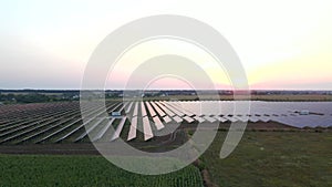 Drone fly over Solar Farm. Renewable green energy and electrical technology. Field of Solar Panels Stands in a Row in