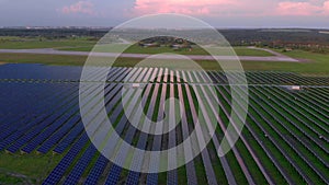 Drone fly over Solar Farm. Renewable green energy and electrical technology. Field of Solar Panels Stands in a Row in