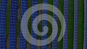 Drone fly over Solar Farm. Renewable green energy and electrical technology. Field of Solar Panels Stands in a Row in