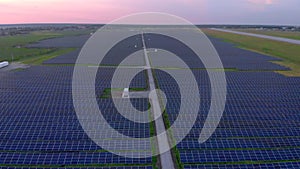 Drone fly over Solar Farm. Renewable green energy and electrical technology. Field of Solar Panels Stands in a Row in