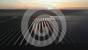 Drone fly over Solar Farm. Renewable green energy and electrical technology. Field of Solar Panels Stands in a Row in