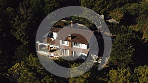 Drone flying above beautiful mediterranean house resort mansion in Italy surrounded by green trees on sunny clear day.