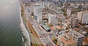 Drone flying above Colombo coast, Sri Lanka. Amazing aerial view of city street traffic, modern buildings and ocean.