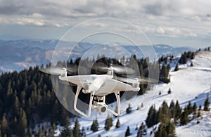 Drone flying above mountain top in winter