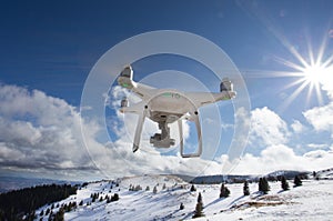 Drone flying above mountain top in winter