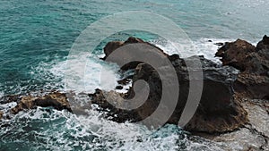 Drone flying along cliff beach. Beautiful coastline with waves. Bird view